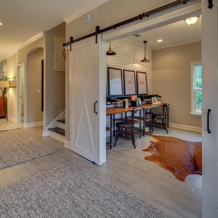 Mid-sized country home studio in Jacksonville with beige walls, laminate floors, no fireplace and a freestanding desk.