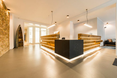 This is an example of a contemporary foyer in Berlin with beige walls and grey floors.