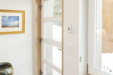 Inspiration for an industrial gray floor single front door remodel in DC Metro with white walls and a white front door