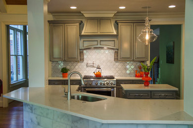 Example of an enclosed kitchen design in Raleigh with gray cabinets, quartzite countertops, glass tile backsplash, stainless steel appliances and an island