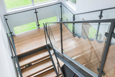 Mid-sized modern wood u-shaped staircase in Houston with open risers.
