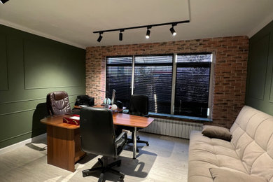 Modelo de sala de manualidades contemporánea de tamaño medio sin chimenea con paredes verdes, suelo de linóleo, escritorio independiente, suelo beige y ladrillo