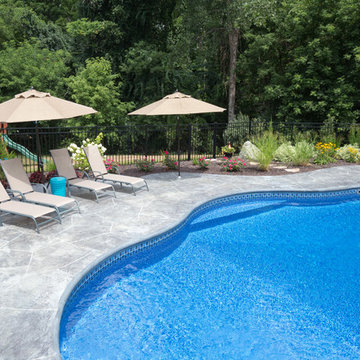 irregular shaped swimming pool with stamped concrete patio