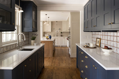 Example of a classic medium tone wood floor kitchen design in Minneapolis with an undermount sink, porcelain backsplash and blue countertops