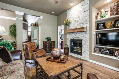 Mid-sized elegant open concept dark wood floor and brown floor living room photo in Dallas with beige walls, a standard fireplace, a stone fireplace and a media wall