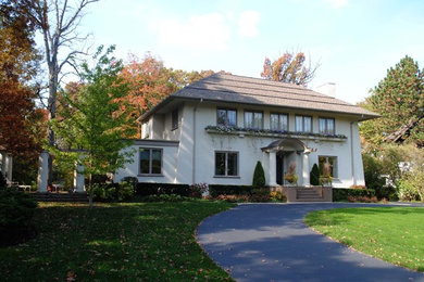 Photo of a mid-sized traditional two-storey stucco white house exterior in Chicago with a hip roof and a shingle roof.