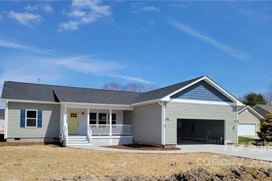 Inspiration for a mid-sized one-story vinyl exterior home remodel in Other with a shingle roof and a black roof