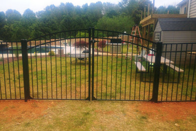 Imagen de jardín tradicional grande con portón y con metal