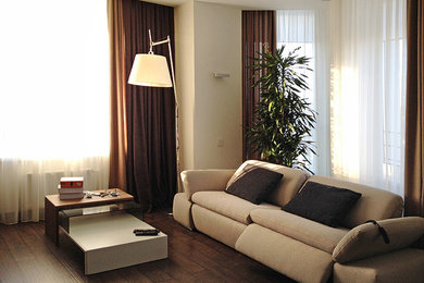 На фото: гостиная комната среднего размера в современном стиле с белыми стенами, полом из ламината и отдельно стоящим телевизором