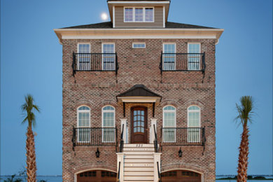 Example of a large beach style brown three-story brick house exterior design in Other with a hip roof and a shingle roof