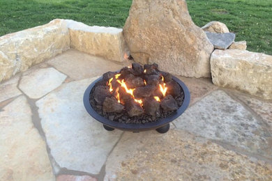 Patio - small traditional backyard stone patio idea in Other with a fire pit and no cover
