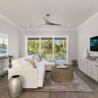 Inspiration pour une salle de cinéma traditionnelle de taille moyenne et fermée avec un mur gris, un sol en bois clair, un téléviseur fixé au mur et un sol marron.