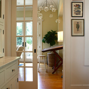 Foto di un ingresso o corridoio classico con pareti beige, pavimento in legno massello medio e pavimento arancione