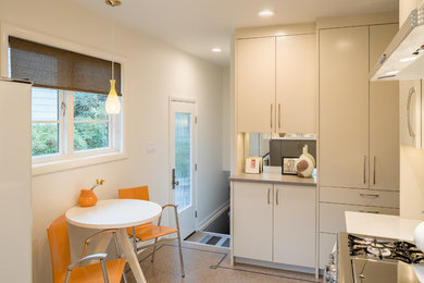 Mid-sized mid-century modern u-shaped linoleum floor eat-in kitchen photo in Portland with an undermount sink, flat-panel cabinets, quartz countertops, multicolored backsplash, ceramic backsplash, white appliances and no island