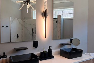 Doorless shower - modern master black and white tile and porcelain tile porcelain tile and double-sink doorless shower idea in Other with gray walls, quartzite countertops, a hinged shower door, white countertops and a built-in vanity