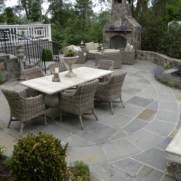 Stone fireplace, walls and steps onto intricate flagstone paving