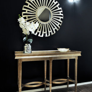 Foto på en liten vintage hall, med svarta väggar och mörkt trägolv