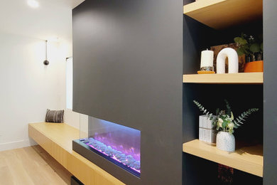 Example of a mid-sized danish open concept living room design in Los Angeles with a corner fireplace and a plaster fireplace
