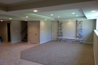This is an example of a large traditional look-out basement in Kansas City with grey walls, carpet and beige floor.