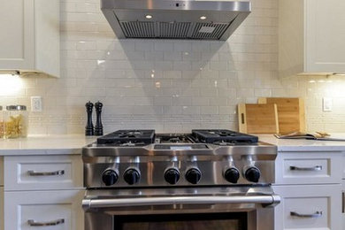 Large transitional u-shaped medium tone wood floor and brown floor open concept kitchen photo in Edmonton with shaker cabinets, quartz countertops, subway tile backsplash, stainless steel appliances, an island, an undermount sink, white cabinets and white backsplash