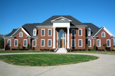Huge arts and crafts two-story brick exterior home photo in Nashville with a shingle roof