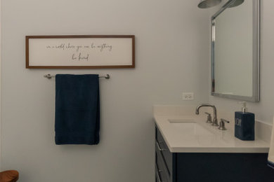 Источник вдохновения для домашнего уюта: детская ванная комната среднего размера в стиле кантри с фасадами в стиле шейкер, синими фасадами, ванной в нише, душем над ванной, раздельным унитазом, белой плиткой, керамической плиткой, белыми стенами, полом из керамогранита, врезной раковиной, столешницей из искусственного кварца, разноцветным полом, белой столешницей, тумбой под одну раковину и напольной тумбой