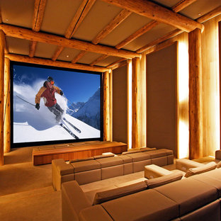 Home theater - rustic enclosed carpeted and beige floor home theater idea in Denver with brown walls and a projector screen