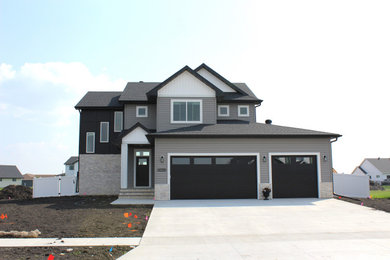 Inspiration for a mid-sized gray two-story mixed siding and board and batten exterior home remodel in Other with a shingle roof and a black roof