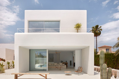 Diseño de fachada de casa blanca y blanca minimalista grande de dos plantas con revestimiento de hormigón, tejado plano y tejado de varios materiales