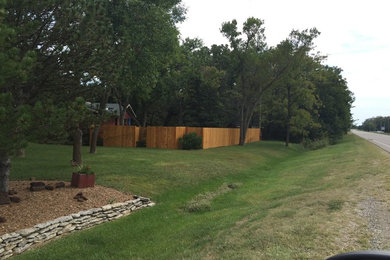 Photo of a large traditional partial sun front yard mulch landscaping in Other.