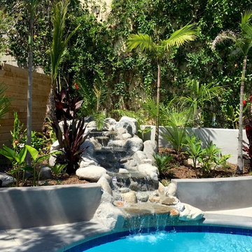 Contemporary tropical waterfall cascades through Hawaiian inspired plantings