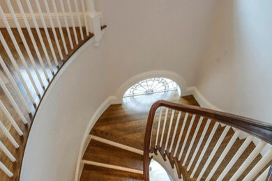 Photo of a mid-sized traditional wood spiral staircase in Boston with wood risers and wood railing.