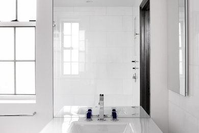 Photo of a small eclectic master bathroom in New York with glass-front cabinets, white cabinets, a curbless shower, a wall-mount toilet, white tile, marble, white walls, marble floors, an integrated sink, glass benchtops, white floor, an open shower and white benchtops.