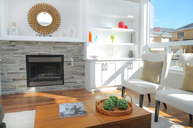 Example of a mid-sized trendy formal and open concept dark wood floor and brown floor living room design in Orange County with white walls, a standard fireplace and a stone fireplace