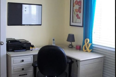 Imagen de despacho contemporáneo de tamaño medio con paredes amarillas, suelo de madera en tonos medios, escritorio independiente y suelo marrón