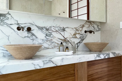 Large contemporary master bathroom in Sydney with furniture-like cabinets, medium wood cabinets, a freestanding tub, an open shower, a one-piece toilet, beige tile, porcelain tile, porcelain floors, a vessel sink, marble benchtops, an open shower, white benchtops, a niche, a double vanity and a floating vanity.