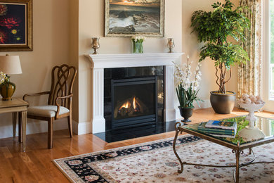 Photo of a mid-sized traditional formal open concept living room in Boston with beige walls, medium hardwood floors, a standard fireplace, a stone fireplace surround, no tv and brown floor.