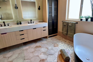 Example of a large trendy master brown tile and porcelain tile pebble tile floor, multicolored floor and double-sink bathroom design in Other with flat-panel cabinets, light wood cabinets, a one-piece toilet, brown walls, an undermount sink, quartz countertops, gray countertops and a floating vanity