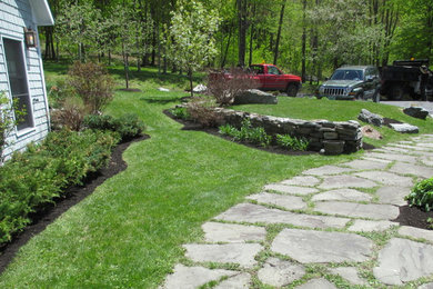 This is an example of a large traditional partial sun side yard mulch retaining wall landscape in Burlington.
