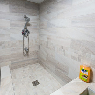 Photo of a medium sized classic l-shaped utility room in DC Metro with a submerged sink, raised-panel cabinets, grey cabinets, granite worktops, beige walls, ceramic flooring, a stacked washer and dryer, beige floors and multicoloured worktops.