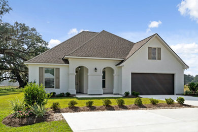 Mid-sized elegant white one-story painted brick exterior home photo in New Orleans with a shingle roof and a brown roof