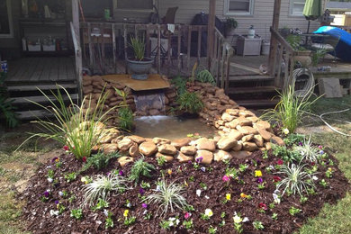 Inspiration for a mid-sized partial sun front yard water fountain landscape in Other.