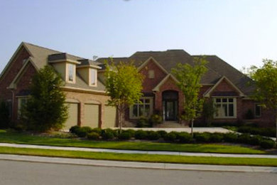 Large red two-story brick exterior home photo in Indianapolis