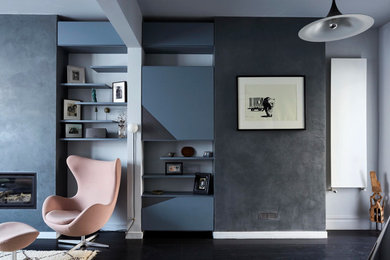 Medium sized modern enclosed living room in London with grey walls, painted wood flooring, a wood burning stove, a concrete fireplace surround and black floors.