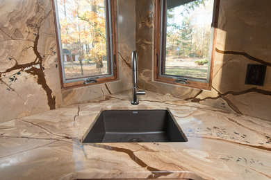 Example of a mid-sized trendy l-shaped light wood floor open concept kitchen design in DC Metro with an undermount sink, flat-panel cabinets, medium tone wood cabinets, quartzite countertops, brown backsplash, stone slab backsplash, stainless steel appliances and an island
