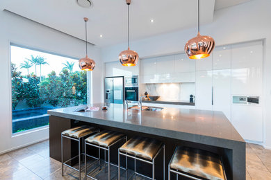 This is an example of a mid-sized modern single-wall eat-in kitchen in Brisbane with white cabinets, ceramic splashback, ceramic floors and with island.
