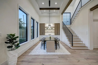 Large vinyl floor, brown floor and exposed beam kitchen/dining room combo photo in Houston with white walls