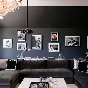 Inspiration for a large contemporary enclosed medium tone wood floor home theater remodel in Nashville with black walls and a projector screen