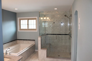 This is an example of a large traditional master bathroom in Denver with an undermount sink, recessed-panel cabinets, white cabinets, granite benchtops, a drop-in tub, a double shower, a two-piece toilet, gray tile, porcelain tile, grey walls and porcelain floors.