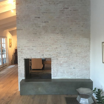 Concrete hearth white washed brick fireplace surround